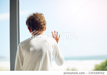 Sad, depression and hope of a child at window while bored lonely and thinking. Depressed, psychology and autism boy child with anxiety problem in isolation with hand by mockup space in house Sad, depression and hope of a child at window while bored lonely and thinking. Depressed, psychology and autism boy child with anxiety problem in isolation with hand by mockup space in house 134169542