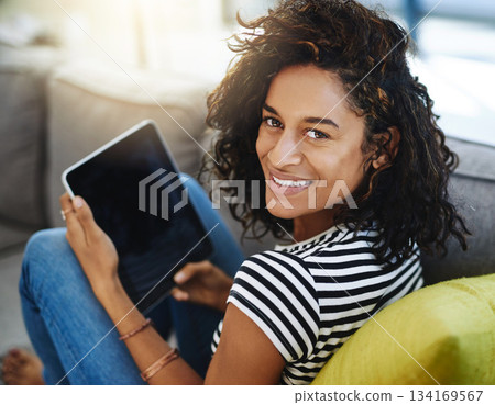 Happy, tablet and portrait of woman on sofa in home for network, online website and social media. Communication, relax and African female person on digital tech for videos, streaming and internet 134169567