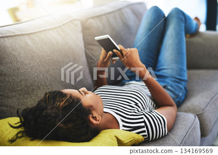Relax, phone and woman laying on sofa in home for network, online website and social media. Communication, mobile app and happy female person on smartphone for chatting, text message and internet 134169569