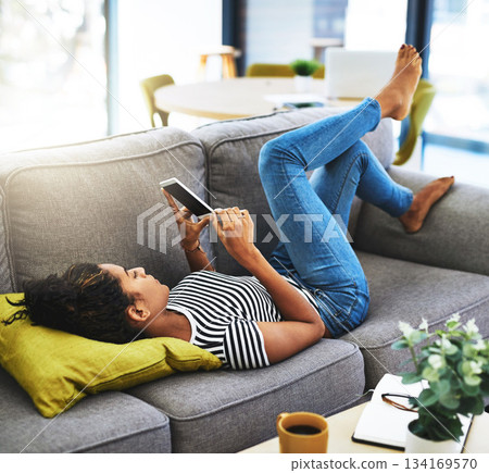 Weekend, phone and woman relax on sofa in home for network, online website and social media. Communication, mobile app and female person on smartphone for chat, text message and internet connection 134169570