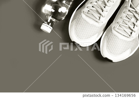 Running shoes and water bottle for workout preparation. Color of 2026 year dancer in the white cloud Running shoes and water bottle for workout preparation. Color of 2026 year dancer in the white cloud 134169656