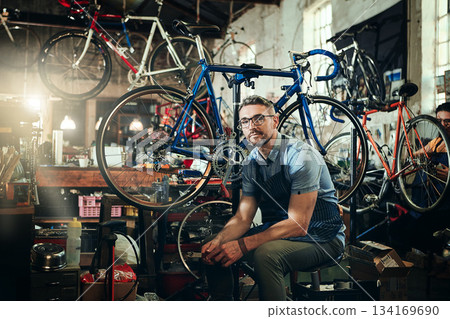 Portrait, wrench and serious repair man in bicycle shop, store or cycling workshop. Face, bike mechanic and male person, business owner or mature professional technician with glasses and confidence. Portrait, wrench and serious repair man in bicycle shop, store or cycling workshop. Face, bike mechanic and male person, business owner or mature professional technician with glasses and confidence. 134169690