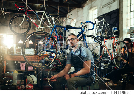 Portrait, tools and serious repair man in bicycle shop, store or cycling workshop. Face, bike mechanic and male person, business owner or mature professional technician with glasses and confidence. Portrait, tools and serious repair man in bicycle shop, store or cycling workshop. Face, bike mechanic and male person, business owner or mature professional technician with glasses and confidence. 134169691