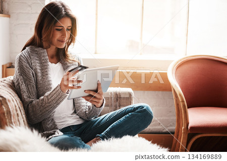 Relax, tablet and credit card with a woman online shopping on a sofa in the living room of her home. Ecommerce, finance and fintech banking with a young female online customer or shopper in her house Relax, tablet and credit card with a woman online shopping on a sofa in the living room of her home. Ecommerce, finance and fintech banking with a young female online customer or shopper in her house 134169889