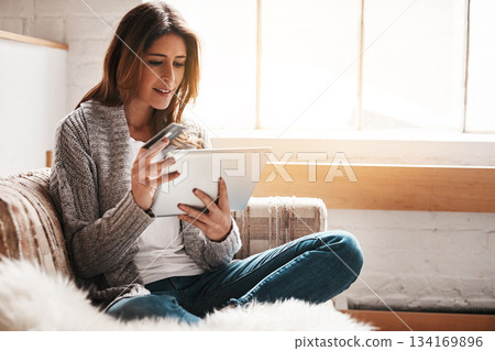 Bank, tablet and credit card with a woman online shopping on a sofa in the living room of her home. Ecommerce, finance payment and fintech banking with a young female online customer in her house 134169896
