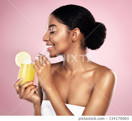 Happy woman, healthy orange juice and glass in studio, pink background and detox for weight loss. African model, citrus smoothie and vitamin c fruits for vegan nutrition, diet drink or natural beauty 134170063
