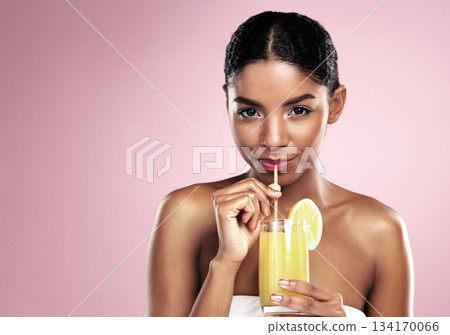 Portrait of woman, glass and orange juice in studio for healthy nutrition, vitamin c or mockup on pink background. African model drinking fruit cocktail, citrus smoothie and natural diet for skincare 134170066