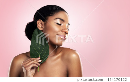 Happy woman, leaf and natural beauty in studio, pink background and mockup for aesthetic cosmetics. Face, african model and skincare from plants, green leaves and sustainability of vegan dermatology Happy woman, leaf and natural beauty in studio, pink background and mockup for aesthetic cosmetics. Face, african model and skincare from plants, green leaves and sustainability of vegan dermatology 134170122