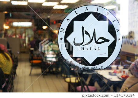 A sticker on a restaurant that is certified as serving halal food 134170184