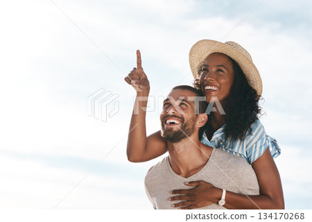Sky, piggyback and happy couple pointing at space with nature on romantic summer holiday travel and mockup. Love, man and woman on adventure with happiness on date, romance and vacation together. Sky, piggyback and happy couple pointing at space with nature on romantic summer holiday travel and mockup. Love, man and woman on adventure with happiness on date, romance and vacation together. 134170268