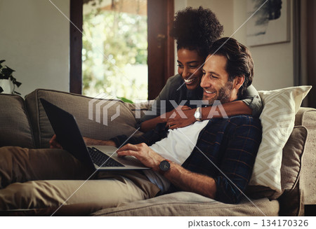 Laptop, subscription and an interracial couple watching a movie using an online streaming service for entertainment. Computer, relax or internet with a man and woman bonding together over a video Laptop, subscription and an interracial couple watching a movie using an online streaming service for entertainment. Computer, relax or internet with a man and woman bonding together over a video 134170326