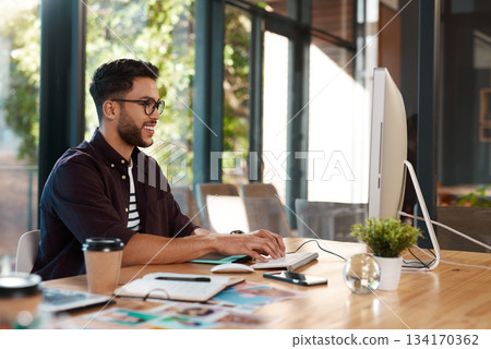 Office, designer and man typing on computer at desk while online for search or creative work. Happy male entrepreneur person with internet connection and glasses for design project or writing email 134170362