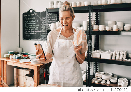 Happy woman, pottery and selfie in small business for social media, advertising or vlog at store. Female person or retail owner smiling with clay bowl for photo or online post on mobile smartphone Happy woman, pottery and selfie in small business for social media, advertising or vlog at store. Female person or retail owner smiling with clay bowl for photo or online post on mobile smartphone 134170411