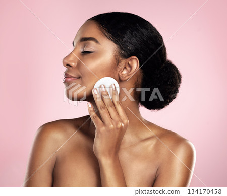 Skincare, beauty and woman with cotton pad on face, smile and makeup removal with luxury skin product in studio. Dermatology, facial cleansing cosmetics and happy model isolated on pink background. Skincare, beauty and woman with cotton pad on face, smile and makeup removal with luxury skin product in studio. Dermatology, facial cleansing cosmetics and happy model isolated on pink background. 134170458