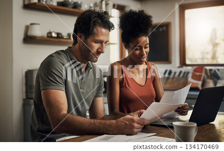 Finance, couple and laptop in a kitchen for planning, budget and savings or paying bills together in their home. Marriage, online and people with documents for tax, mortgage or home loan or insurance Finance, couple and laptop in a kitchen for planning, budget and savings or paying bills together in their home. Marriage, online and people with documents for tax, mortgage or home loan or insurance 134170469