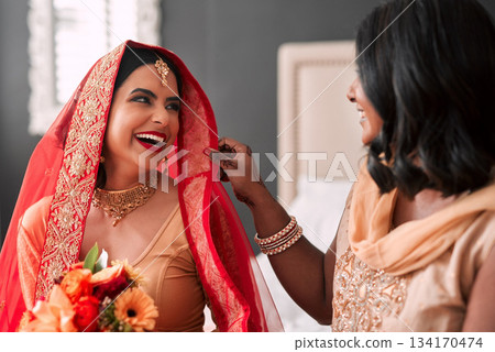 Happy, bride and bridesmaid getting ready for a wedding, laughing and helping in a room. Support, love and a young woman in traditional Indian clothes for marriage ceremony with a friend or sister Happy, bride and bridesmaid getting ready for a wedding, laughing and helping in a room. Support, love and a young woman in traditional Indian clothes for marriage ceremony with a friend or sister 134170474