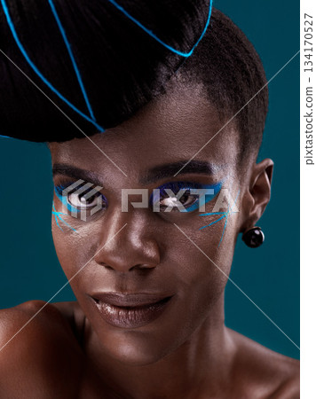 Portrait, makeup and eye shadow with a black woman in studio on a blue background for beauty. Face, hair and cosmetics with an attractive young female model at the salon for fashion or styling 134170527