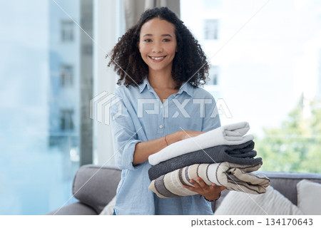 Portrait, laundry and cleaning with a black woman in her home, holding fresh towels during housework. Smile, fabric and washing with a happy young female cleaner in the living room of her apartment 134170643
