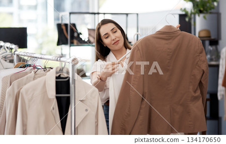 Shopping, retail and a woman customer in a mall boutique to buy trendy clothes for seasonal fashion. Search, store and sale with a young female consumer in a shop, making a clothing purchase choice 134170650