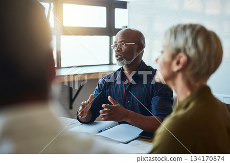 Business people, meeting and leadership of black man in office, talking or speaking. Teamwork, ceo and senior African male professional brainstorming, collaboration or planning strategy in workplace. 134170874