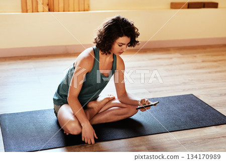 Woman, floor and yoga with phone, texting and reading for health information, search or social media. Girl, smartphone and typing for communication in gym, studio or home for wellness, peace or relax Woman, floor and yoga with phone, texting and reading for health information, search or social media. Girl, smartphone and typing for communication in gym, studio or home for wellness, peace or relax 134170989