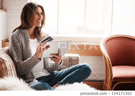 Thinking, tablet and credit card with a woman online shopping on a sofa in the living room of her home. Ecommerce, finance and fintech banking with a young female online customer in her house Thinking, tablet and credit card with a woman online shopping on a sofa in the living room of her home. Ecommerce, finance and fintech banking with a young female online customer in her house 134171302
