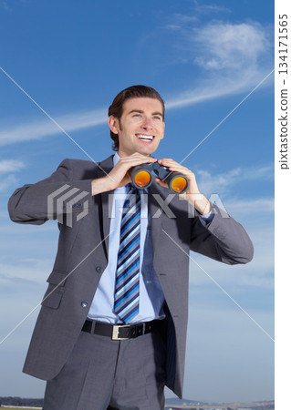 Binoculars, happy and search for business man outdoor with happiness, smile and investigation. Future, searching and businessman in nature with investigate gear and opportunity vision ready for work 134171565