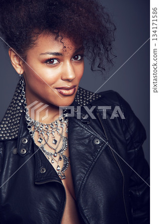 Fashion, style and beauty portrait of woman in studio for trendy clothes, leather jacket or jewellery. Face of African female model with makeup, cosmetic and punk or rock aesthetic on grey background Fashion, style and beauty portrait of woman in studio for trendy clothes, leather jacket or jewellery. Face of African female model with makeup, cosmetic and punk or rock aesthetic on grey background 134171586