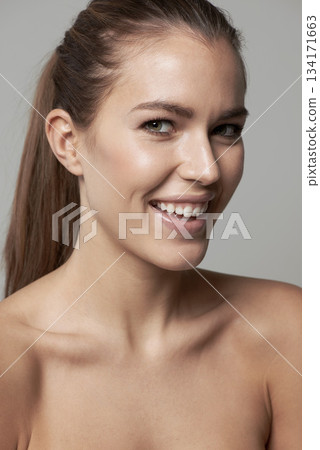 Happy, beauty and portrait of woman in studio for wellness, facial treatment and self care. Dermatology, skincare and face of female person with natural cosmetics, makeup and smile on gray background Happy, beauty and portrait of woman in studio for wellness, facial treatment and self care. Dermatology, skincare and face of female person with natural cosmetics, makeup and smile on gray background 134171663