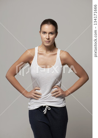 Woman, portrait and hands on hip in confidence for body fitness, health and wellness against a gray studio background. Proud or confident female person or model posing in pride for exercise clothing Woman, portrait and hands on hip in confidence for body fitness, health and wellness against a gray studio background. Proud or confident female person or model posing in pride for exercise clothing 134171666
