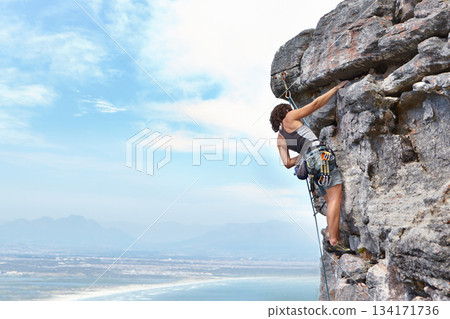 Rock climbing, travel and blue sky with woman on mountain for adventure, cliff and space. Strong, freedom and mockup with female climber training in nature for courage, safety and workout challenge 134171736