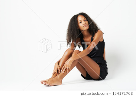 Fashion, beauty and portrait of African woman on floor of studio with trendy, stylish and casual clothes. Style, mockup and female person with confidence, attitude and beautiful on white background Fashion, beauty and portrait of African woman on floor of studio with trendy, stylish and casual clothes. Style, mockup and female person with confidence, attitude and beautiful on white background 134171768