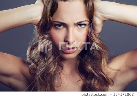 Face, angry or frustrated young woman and in a studio background. Serious or concerned portrait, health wellness and female model isolated alone with headshot in backdrop for skincare or cosmetic 134171808