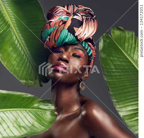 Leaf, makeup and portrait of black woman in studio for glow or natural cosmetics on grey background. Culture, beauty and face of African lady model with plant for cosmetology and jungle aesthetic Leaf, makeup and portrait of black woman in studio for glow or natural cosmetics on grey background. Culture, beauty and face of African lady model with plant for cosmetology and jungle aesthetic 134172051