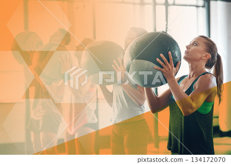 Gym, fitness and woman throw medicine ball for exercise, workout and training in class. Athlete people together for power challenge, commitment and strong muscle at health club with a mockup overlay Gym, fitness and woman throw medicine ball for exercise, workout and training in class. Athlete people together for power challenge, commitment and strong muscle at health club with a mockup overlay 134172070