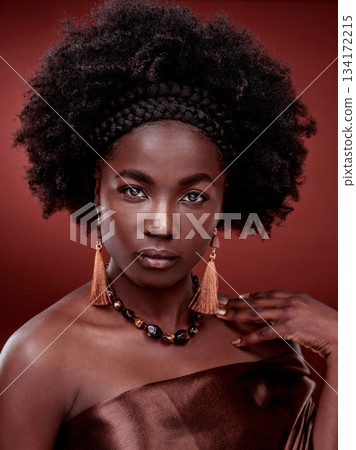 Beauty, portrait and black woman with fashion in studio isolated on a red background. Face, makeup cosmetics and serious African female model with stylish outfit, traditional earings and jewelry. Beauty, portrait and black woman with fashion in studio isolated on a red background. Face, makeup cosmetics and serious African female model with stylish outfit, traditional earings and jewelry. 134172215