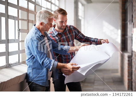 Architect, teamwork and holding blueprint for reading, planning or analysis of real estate development. Men, paper and design at property, construction site or building with talk, discussion or help 134172261