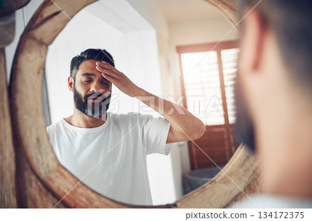 Stress, headache and man by a mirror in the bathroom while doing a skincare routine in his home. Migraine, tired and mature male person doing a health dermatology face treatment in his modern house. Stress, headache and man by a mirror in the bathroom while doing a skincare routine in his home. Migraine, tired and mature male person doing a health dermatology face treatment in his modern house. 134172375