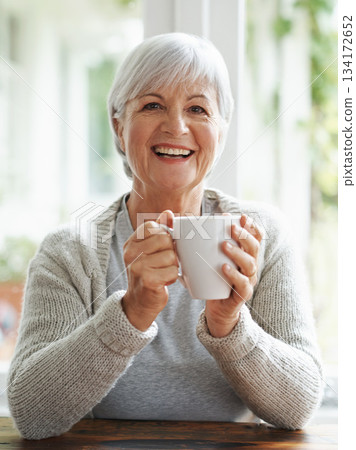 Portrait, happy old woman and drinking coffee in home for break, relaxing morning and retirement. Face, laughing and senior lady enjoy cup of tea, warm beverage and hot drink in house with happiness Portrait, happy old woman and drinking coffee in home for break, relaxing morning and retirement. Face, laughing and senior lady enjoy cup of tea, warm beverage and hot drink in house with happiness 134172652
