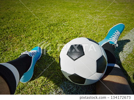 Sport, field and shoes of man with soccer ball outdoor, relax and resting after fitness or training. Football, pov and male player relaxing on grass at park after workout, match or sports performance 134172673