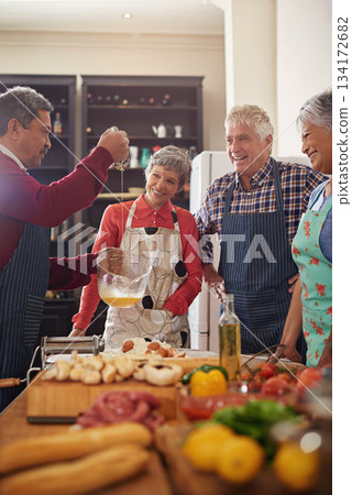 Cooking, food and senior friends in the kitchen of a home for a dinner party or social celebration event. Diversity, retirement or community with a group of men and women in a house to prepare a meal 134172682