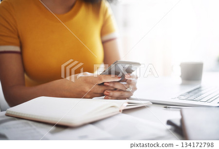 Hands, woman with a smartphone and laptop by her desk in office. Social media or communication, connectivity or networking and female worker on cellphone reading or writing an email at workplace 134172798