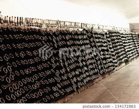 Cellar, wine and bottles in winery, warehouse or factory for storage in interior. Alcohol, manufacturing plant and beverage in storehouse for packing, bottling and alcoholic production in industry. 134172863