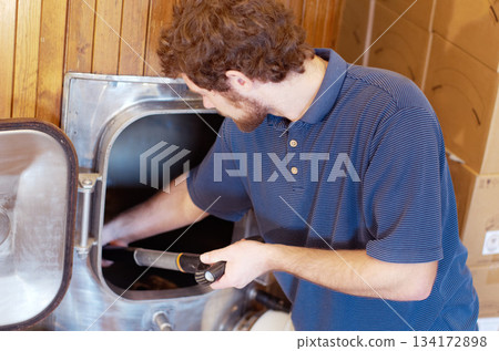 Man is working in brewery, beer manufacturing and productivity in distillery and alcohol industry. Industrial equipment, production of alcoholic drink and male worker brewing cider beverage 134172898