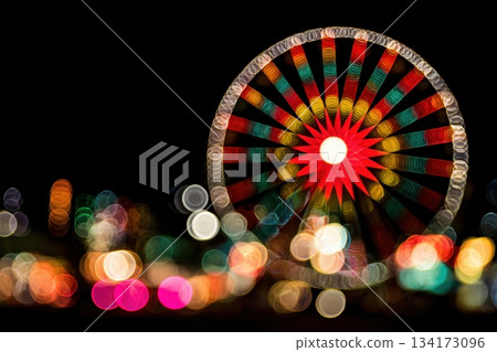 Colorful Ferris wheel lights illuminate the night sky 134173096