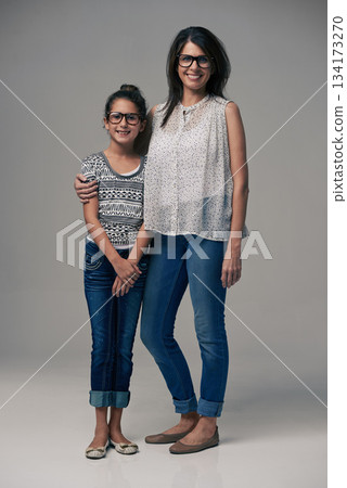 Portrait, mother and girl embrace in studio together on gray background or happy, preteen daughter and mommy with glasses. Family love, single mom and child or loving mama relationship with care 134173270