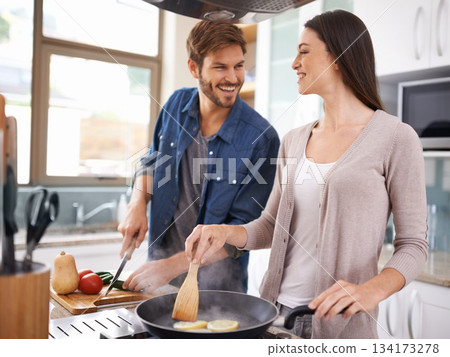 Happy couple, food and cooking together in a pan in the kitchen with healthy organic ingredients for dinner at home. Man helping woman with smile in happiness making meal with vegetables on stove Happy couple, food and cooking together in a pan in the kitchen with healthy organic ingredients for dinner at home. Man helping woman with smile in happiness making meal with vegetables on stove 134173278
