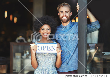 Coffee shop, open and couple portrait as small business owner or team in partnership with pride. Smile of a man and woman with signage, diversity and welcome sign as waiter and barista of restaurant 134173411