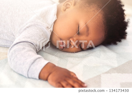 Baby, african and boy sleeping on bed for rest, health and peace for growth, development and relax in family home. Black male infant, tired and sleep in bedroom with fatigue, quiet and calm in house 134173430