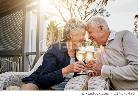 Love, cheers and wine, old couple celebrate romance or anniversary on patio of vacation home. Happiness, senior man and woman touching heads with champagne toast, smile and romantic date on holiday. 134173456